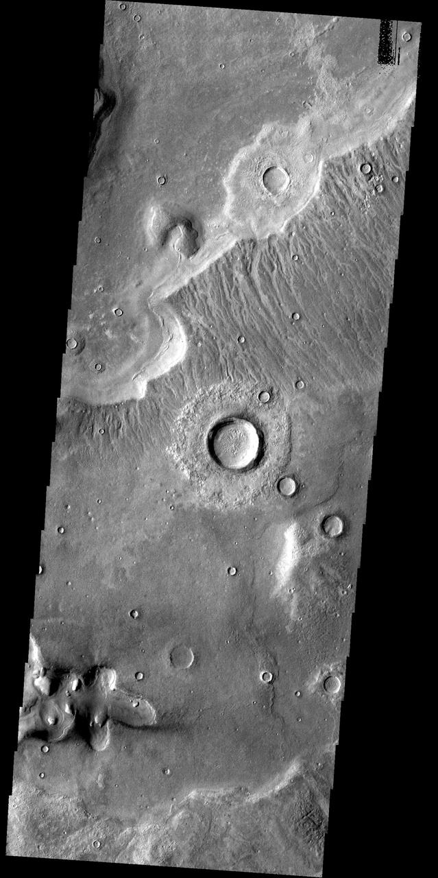 This image from the Deuteronilus Mensae region shows an interesting portion of the martian dichotomy. It appears that the crater in the upper part of the image is being re-exposed after burial