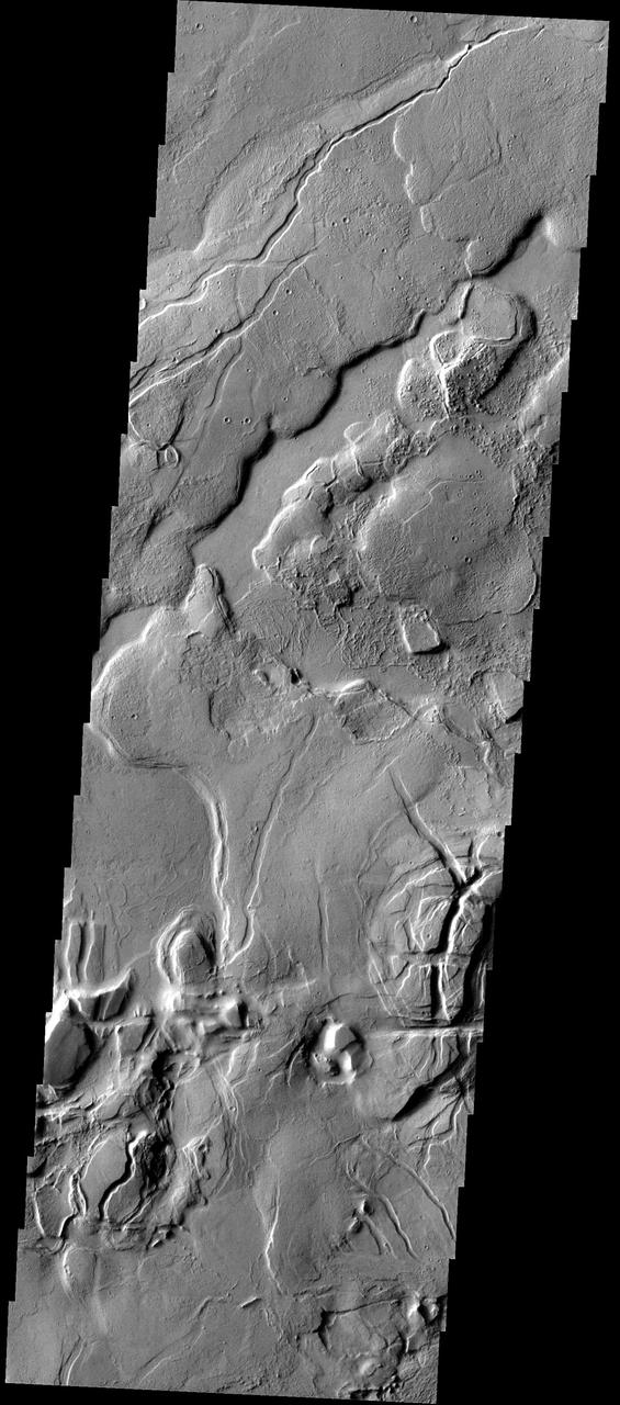 This complex region of lava flows and fracturing is located at the eastern margin of the Tharsis Volcanic Complex