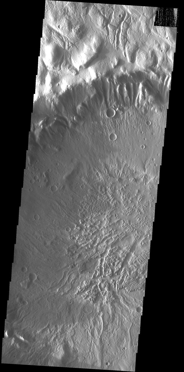 This image shows part of the large unnamed crater located on Acheron Fossae. Numerous channels dissect the crater rim and the crater floor has a rugged texture