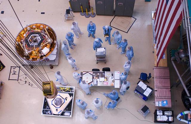 Spacecraft specialists huddle to discuss the critical lift of NASA Phoenix Mars Lander into a thermal vacuum chamber