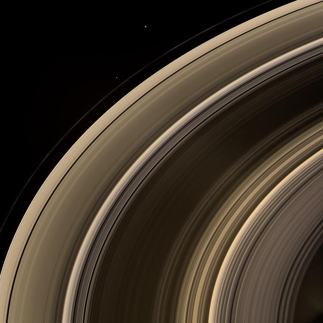 From on high, the Cassini spacecraft spies a group of three ring moons in their travels around Saturn. Janus is seen at top, while Pandora hugs the outer edge of the narrow F ring. More difficult to spot is Pan, which is a mere speck in this view.