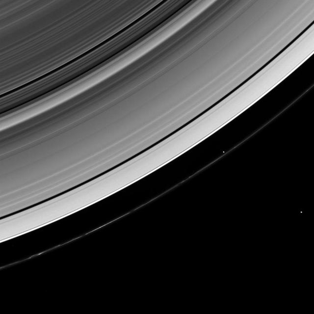 The Cassini spacecraft looks down from a high-inclination orbit to spot two of Saturn ring moons