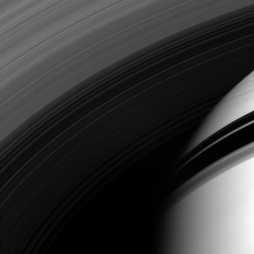 The Cassini spacecraft peers through the gossamer strands of Saturn innermost rings, whose own shadows adorn the planet beyond