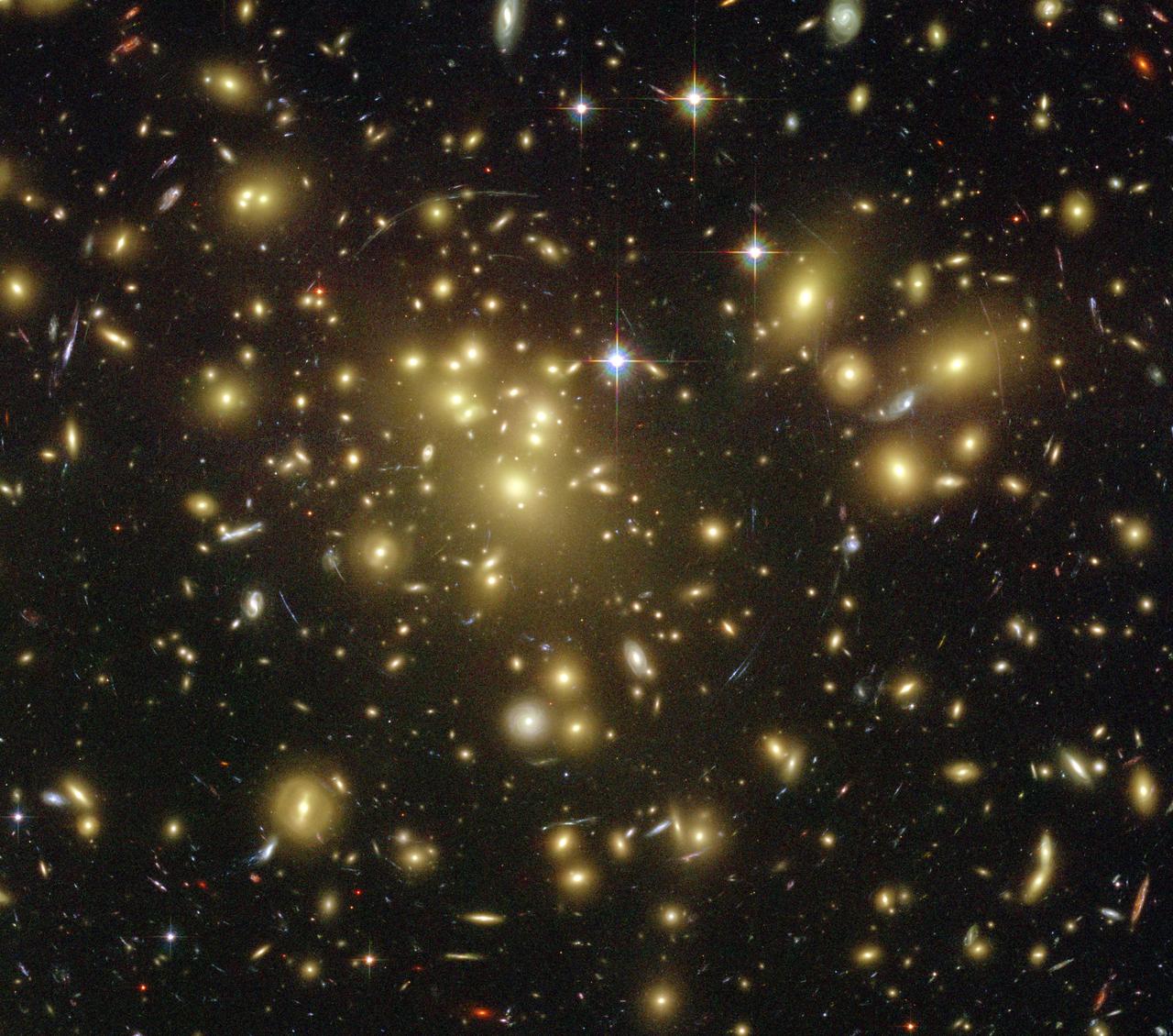 A massive cluster of yellowish galaxies is seemingly caught in a spider web of eerily distorted background galaxies in the left-hand image, taken with the Advanced Camera for Surveys ACS aboard NASA Hubble Space Telescope.