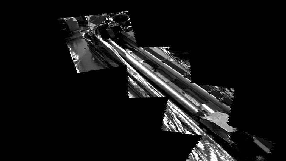 This frame a movie from NASA's Phoenix Mars Lander shows the spacecraft's robotic arm in its stowed configuration, with its biobarrier unpeeled. The arm is still folded up, with its "elbow" shown at upper left and its scoop at bottom right. The biobarrier is the shiny film seen to the left of the arm in this view.  The barrier is an extra precaution to protect Mars from contamination with any bacteria from Earth. While the whole spacecraft was decontaminated through cleaning, filters and heat, the robotic arm was given additional protection because it is the only spacecraft part that will directly touch the ice below the surface of Mars.  Before the arm was heated, it was sealed in the biobarrier, which is made of a trademarked film called Tedlar that holds up to baking like a turkey-basting bag. This ensures that any new bacterial spores that might have come about during the final steps before launch, and during the journey to Mars, will not contact the robotic arm.  After Phoenix landed, springs were used to pop back the barrier, giving it room to deploy. The arm is scheduled to begin to unlatch on the second Martian day of the mission, or Sol 3 (May 28, 2008).  This image was taken on Sol 1 (May 26, 2008) by the spacecraft's Surface Stereo Imager.  http://photojournal.jpl.nasa.gov/catalog/PIA10708
