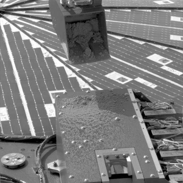 NASA Phoenix Mars Lander used its Robotic Arm during the mission 15th Martian day since landing June 9, 2008 to test a prinkle method for delivering small samples of soil to instruments on the lander deck.