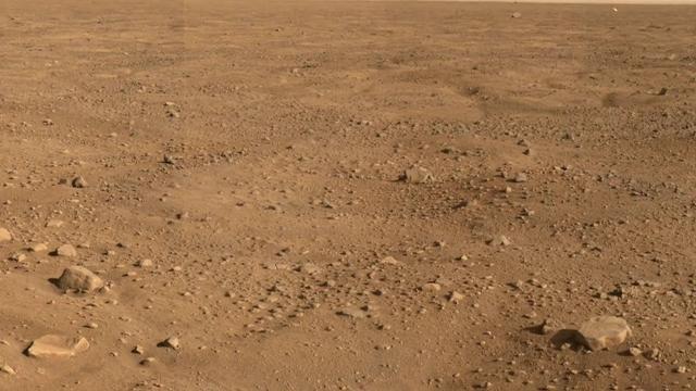 This panorama looks to the southeast and shows rocks casting shadows, polygons on the surface and as the image looks to the horizon, NASA Phoenix Mars Lander backshell gleams in the distance.