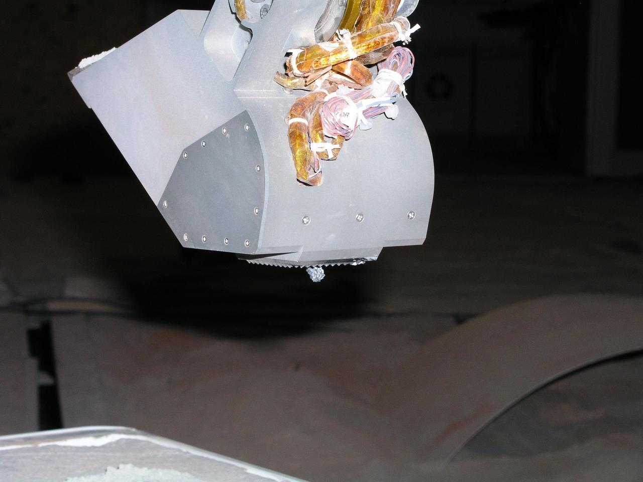 This photograph shows the rasp protruding from the back of the scoop on NASA Phoenix Mars Lander Robotic Arm engineering model in the Payload Interoperability Testbed at the University of Arizona, Tucson.