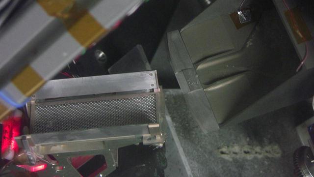 This image shows testing under simulated Mars conditions on Earth in preparation for NASA Phoenix Mars Lander using its robotic arm for delivering a sample to the doors of a laboratory oven.