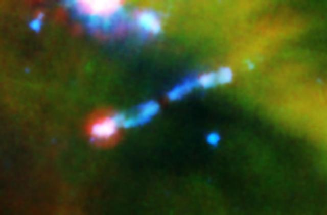 A jet of gas firing out of a very young star can be seen ramming into a wall of material in this infrared image from NASA Spitzer Space Telescope. 