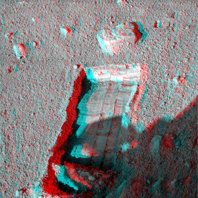The robotic arm on NASA Phoenix Mars Lander enlarged a trench beside a rock called Headless on Sept. 20, 2008 in preparation for sliding the rock into the trench. 3D glasses are necessary to view this image.