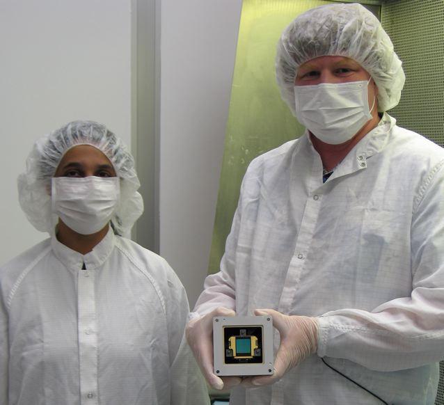 Mike Ressler right and Kalyani Sukhatme of NASA JPL pose in the clean room with a model component, called a focal plane module, of the Mid-Infrared Instrument on NASA James Webb Space Telescope.