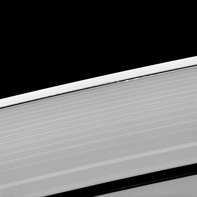 A scalloped look is created in the edges of the Keeler Gap in Saturn outer A ring as the moon Daphnis orbits in the gap.