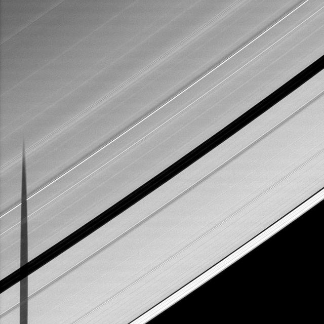 Seen from the unlit side of Saturn A ring, the shadow of the moon Janus is cast across the Encke Gap.