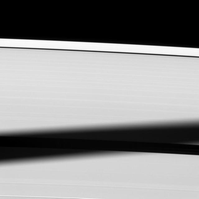 The shadow of the moon Tethys is cast onto Saturn A ring, almost blanketing the Enke Gap.