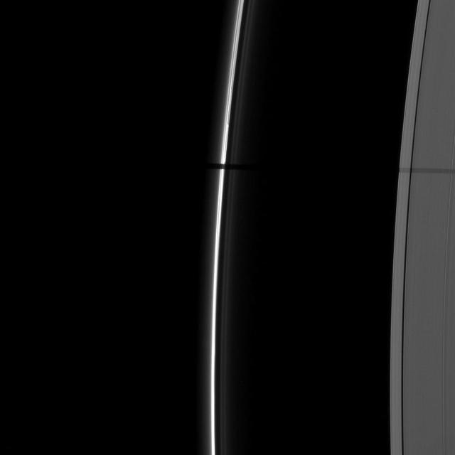A wide shadow is cast onto the thin F ring and the A ring by the moon Janus in this image taken as Saturn approached its August 2009 equinox.