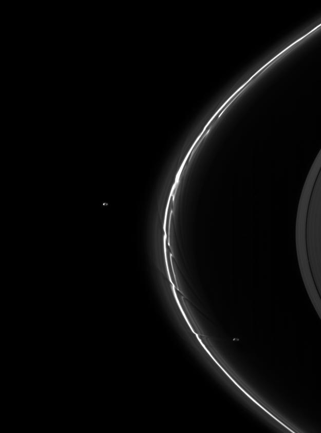 This image shows a pair of moons, Pandora and Prometheus, continuing their shepherding duties near Saturn thin F ring as seen by NASA Cassini spacecraft.