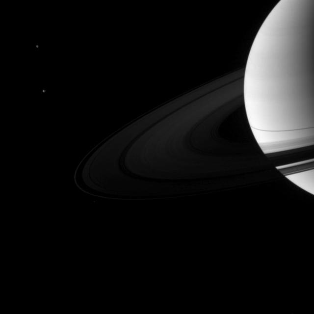 A pair of Saturn moons, Dione and Tethys, accompany the planet and its rings in this image taken shortly after the planet August 2009 equinox by NASA Cassini spacecraft.