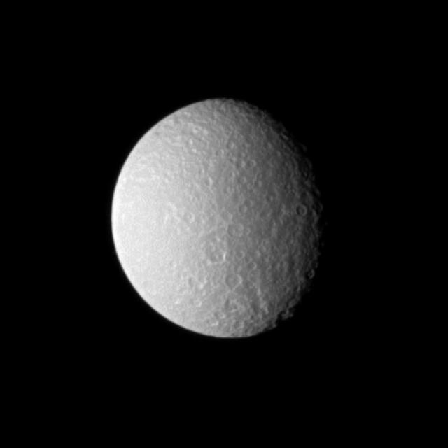 Bright sunlight on Rhea shows off the cratered surface of Saturn second largest moon in this image captured by NASA Cassini Orbiter. The image was taken in visible light with the Cassini spacecraft narrow-angle camera on Sept. 21, 2009.
