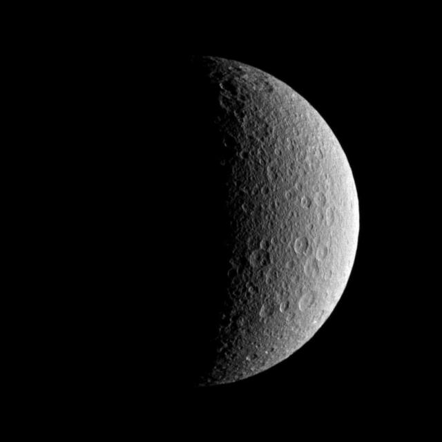 NASA Cassini spacecraft looks toward the battered surface of the moon Rhea.