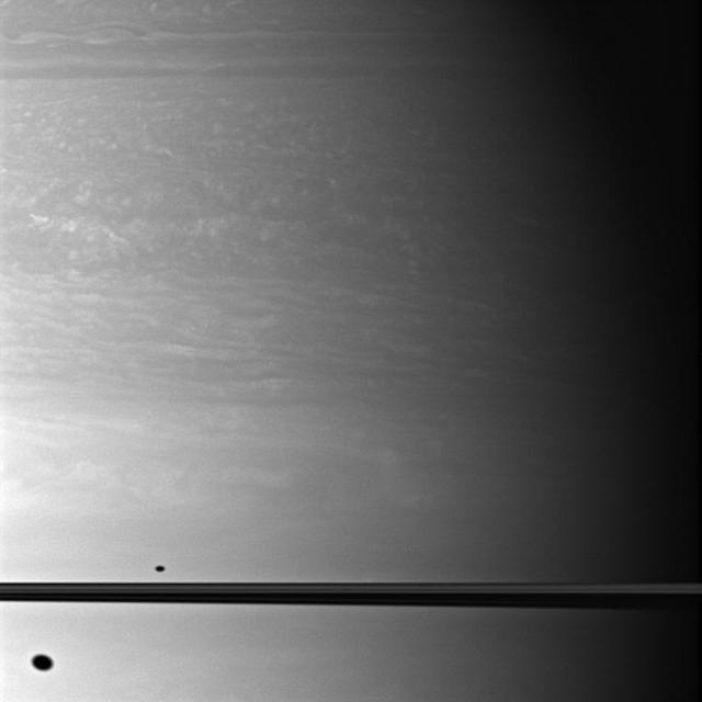 This image, taken by NASA Cassini spacecraft, shows the shadows of two moons as they appear on Saturn, above and below the plane of the planet rings.