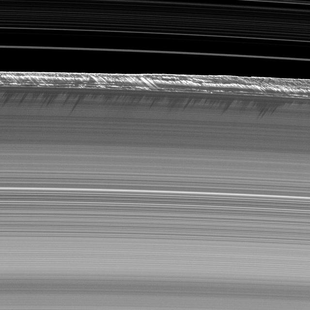 Vertical structures, among the tallest seen in Saturn main rings, rise abruptly from the edge of Saturn B ring to cast long shadows on the ring in this image taken by NASA Cassini spacecraft two weeks before the planet August 2009 equinox.