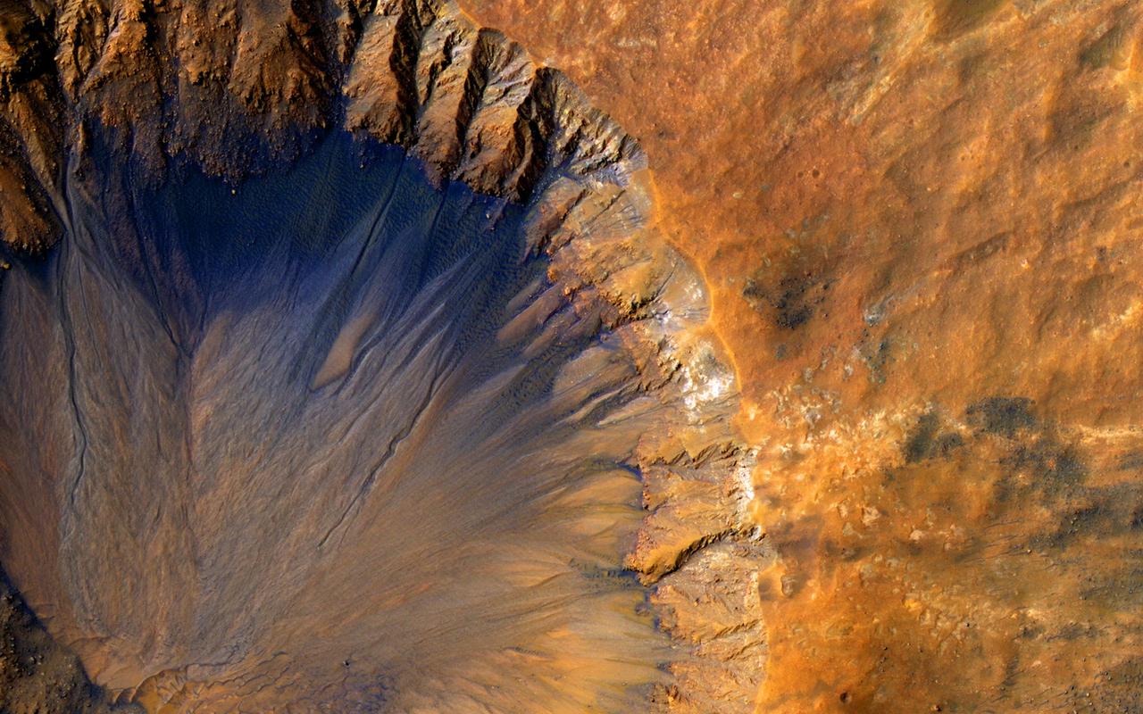 This impact crater, as seen by NASA Mars Reconnaissance Orbiter, appears relatively recent as it has a sharp rim and well-preserved ejecta.