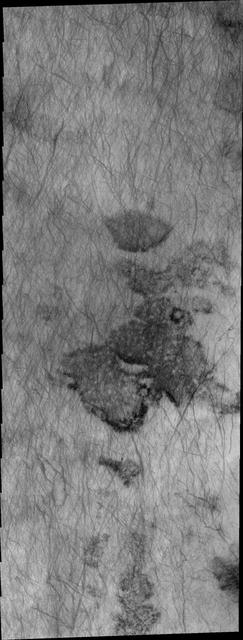 This 2001 Mars Odyssey image shows a region of Aonia Terra criss-crossed with a multitude of dust devil tracks. The tracks show up well on the dusty plains.