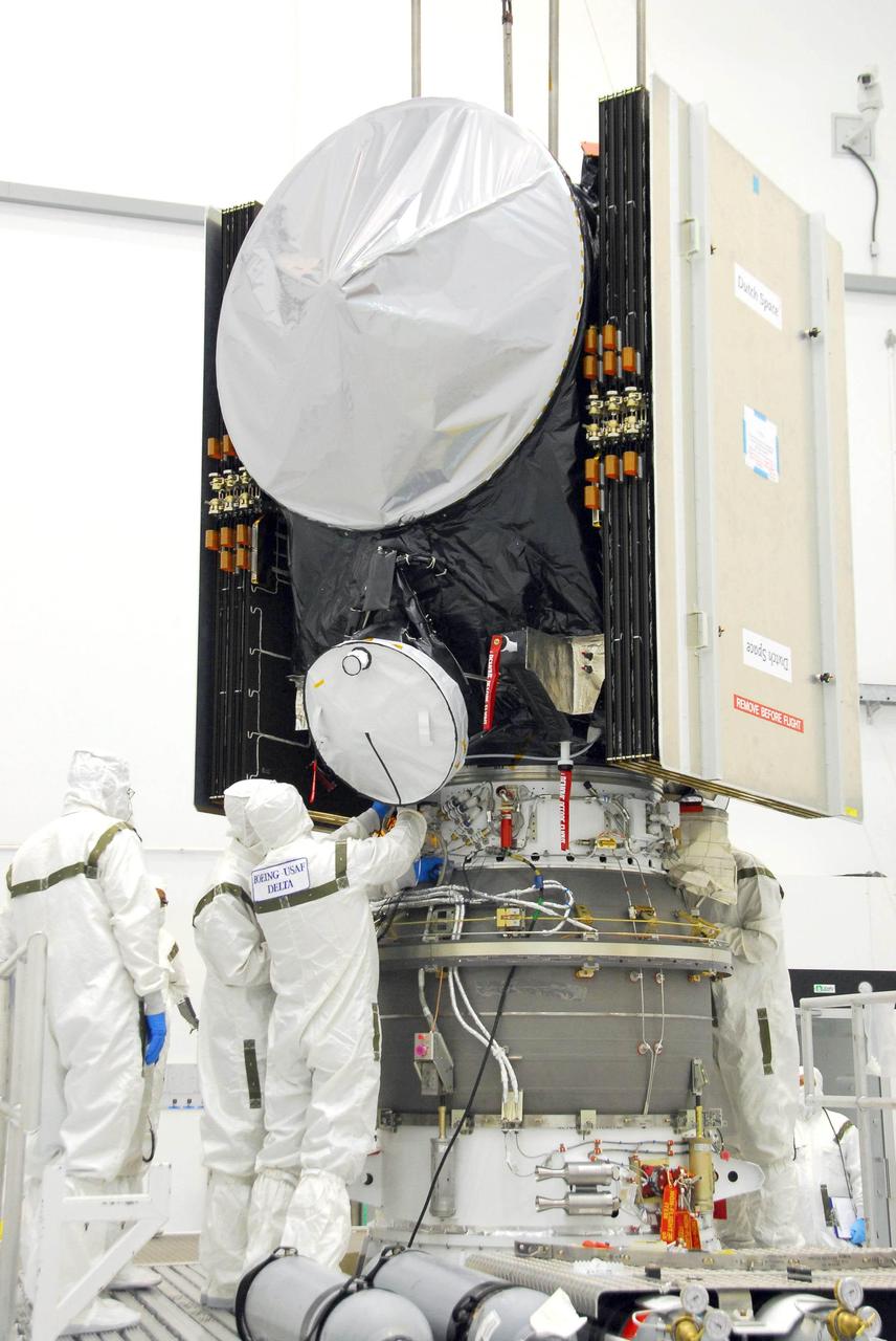 Workers secure the attachments of NASA Dawn spacecraft onto the upper stage booster.