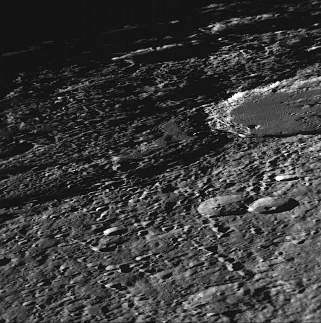NASA Mariner 10 shows a close-up view of craters Vyasa and Stravinsky on Mercury. Stravinsky is a smooth-floored crater partially seen overlying the rim of the larger, rougher crater Vyasa in the center and left.
