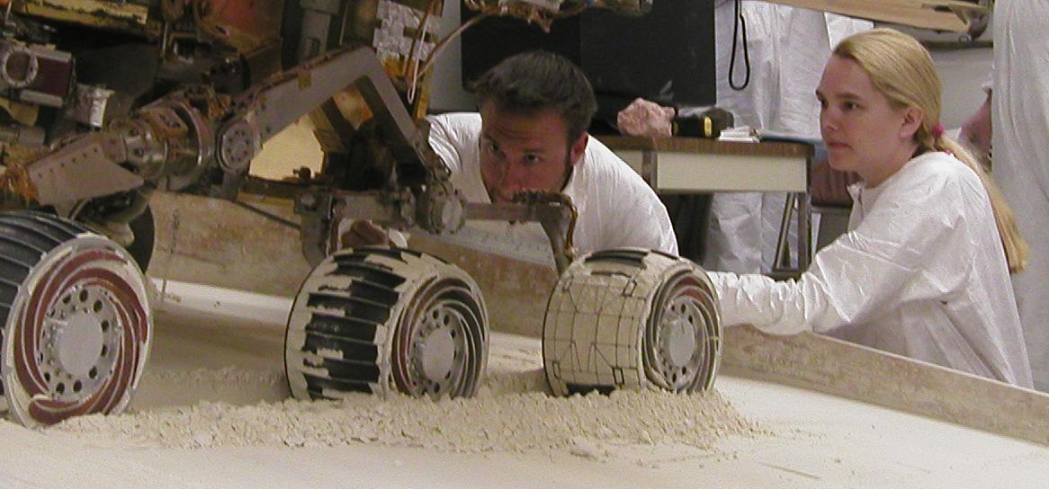 Mike Seibert and Sharon Laubach, engineers on NASA Mars Exploration Rover team at the Jet Propulsion Laboratory, Pasadena, check the exact position of a test rover in preparation for the next test of a possible maneuver for Spirit to use on Mars.