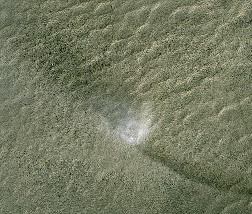 This telescopic view from orbit around Mars catches a Martian dust devil in action in the planet southern hemisphere. The swirling vortex of dust can be seen near the center of the image.