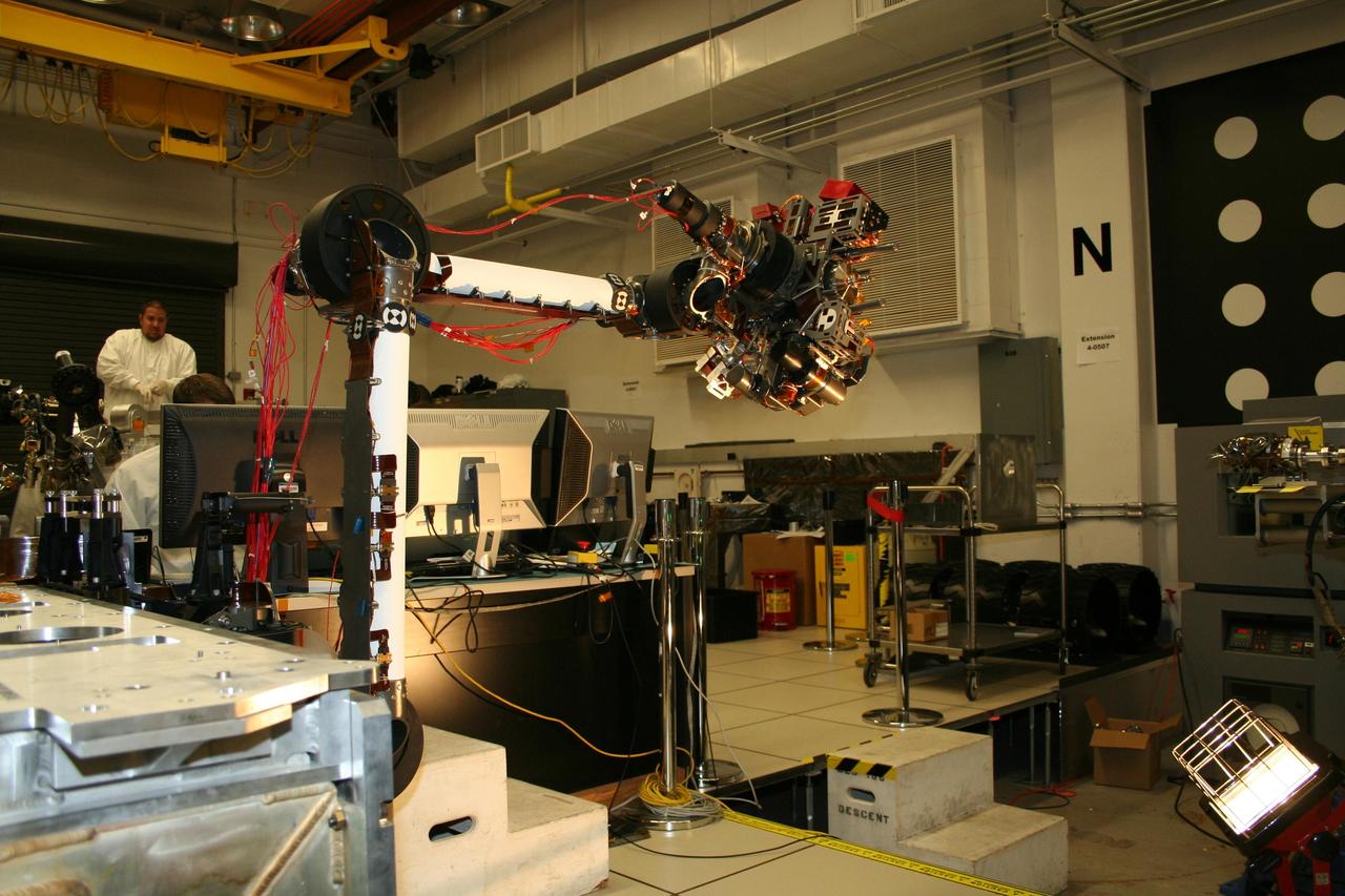 In the middle of this image taken at the Jet Propulsion Laboratory, the long robotic arm of NASA Mars Science Laboratory is bent at nearly a 90-degree angle.