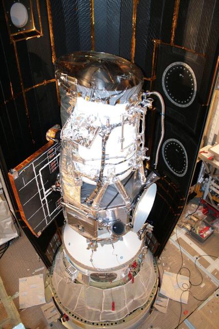 NASA Wide-field Infrared Survey Explorer is shown inside one-half of the nose cone, or fairing, that will protect it during launch.