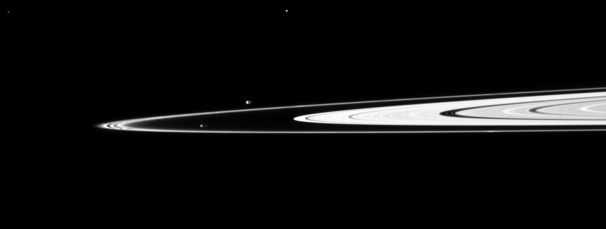 Pandora and Prometheus, the shepherding moons of the F ring, orbit inside and outside the thin ring. The elongated, potato-like shapes of the two moons are both visible in this image taken by NASA Cassini spacecraft.