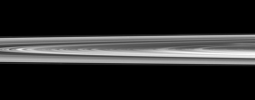 Pan is nearly lost within Saturn rings in this view captured by NASA Cassini spacecraft of a small section of the rings from just above the ringplane.