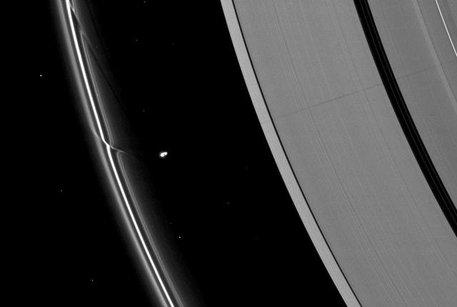The effects of the small moon Prometheus loom large on two of Saturn rings in this image taken by NASA Cassini spacecraft a short time before Saturn August 2009 equinox.