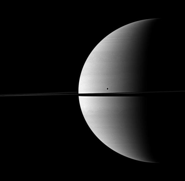 Saturn shares its space with its moon Tethys in this scene captured by NASA Cassini spacecraft. Tethys can be seen above the rings near the middle of the image. This view looks toward the northern, sunlit side of the rings from just above the ringplane.