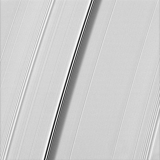 NASA Cassini spacecraft spies two types of waves in Saturn A ring: a spiral density wave on the left of the image and a more pronounced spiral bending wave near the middle.