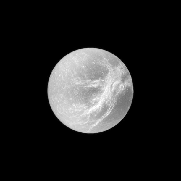 Appearing like the swirls of marble, the wispy terrain of Saturn moon Dione is captured by NASA Cassini spacecraft in a dramatic display of light and dark. These wispy features are a system of braided canyons with bright walls.