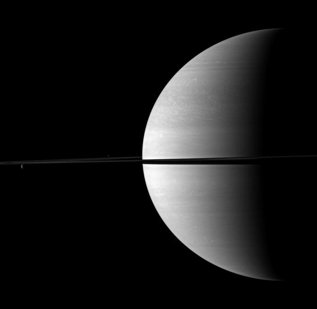 Rhea and Enceladus appear above and below the rings on the left of this image, serving to visually offset the dominance of Saturn in this image taken by NASA Cassini spacecraft.