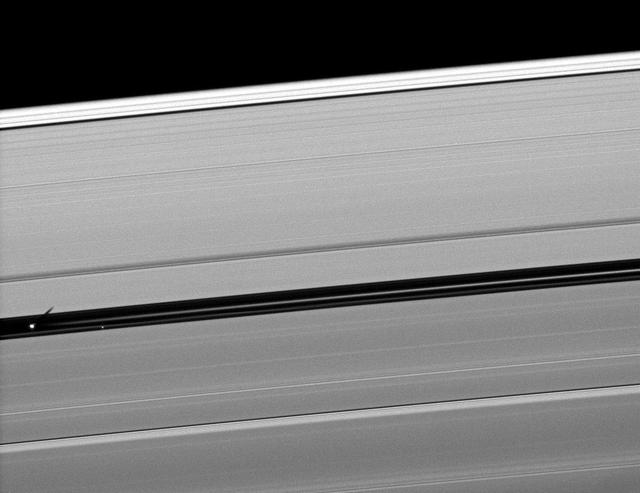 Orbiting in the Encke Gap of Saturn A ring, the moon Pan casts a shadow on the ring in this image taken about six months after the planet August 2009 equinox by NASA Cassini spacecraft.