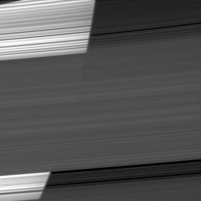 The limb of Saturn appears bright as NASA Cassini spacecraft peers through several of the planet rings. The curvature of the planet can be seen on the bright left half of the image.