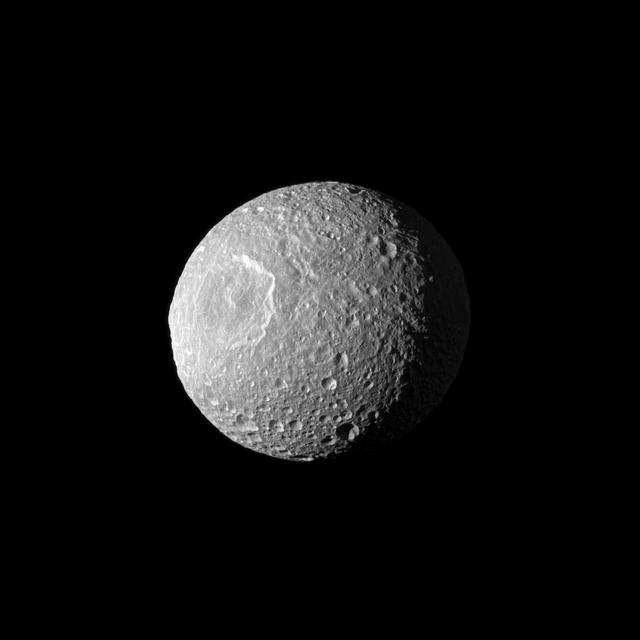 Appearing like a cyclops gazing off into space, Saturn moon Mimas and its large Herschel Crater are profiled from NASA Cassini spacecraft. Herschel Crater is 130 kilometers 80 miles wide and covers most of the left of this image.