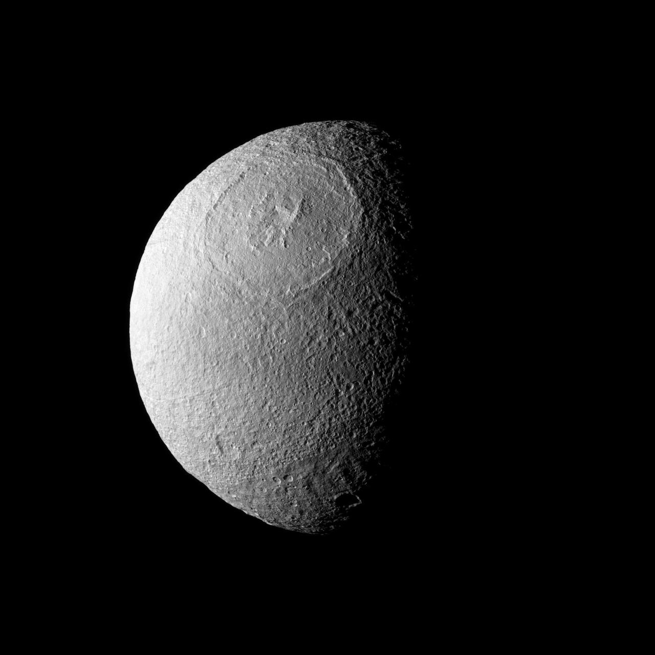Odysseus Crater, with a size of epic proportions, stretches across a large northern expanse on Saturn moon Tethys in this image taken by NASA Cassini spacecraft.