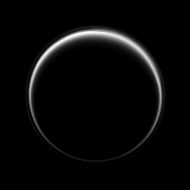 NASA Cassini spacecraft looks toward the dark side of Titan as a circle of light is produced by sunlight scattering through the periphery of the atmosphere of Saturn largest moon. A detached, high-altitude global haze layer encircles the moon.
