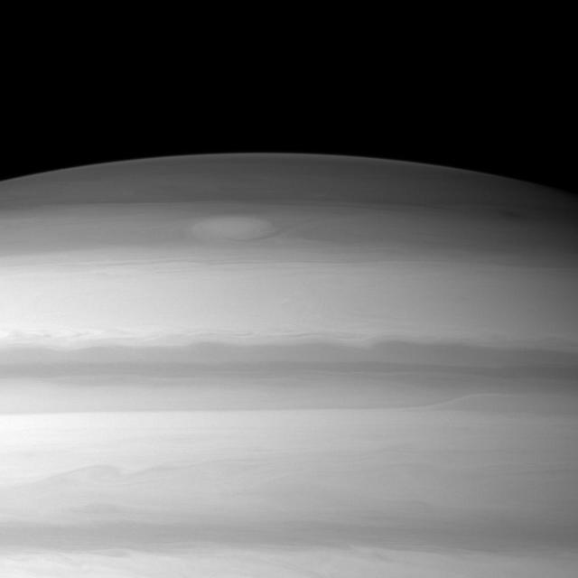 A large cloud formation swirls through the high northern latitudes of Saturn near the top of this image taken by NASA Cassini spacecraft.