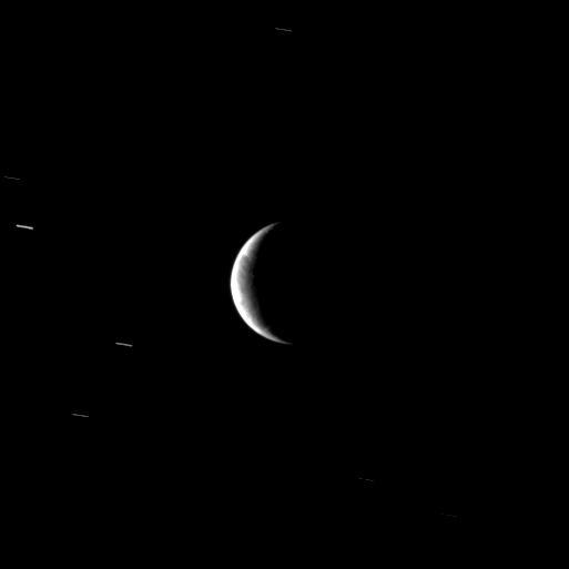 From a distant perspective, NASA Cassini spacecraft sees hints of the unusual surface of Saturn moon Enceladus, a moon where new terrain is created around a geologically active south polar region.