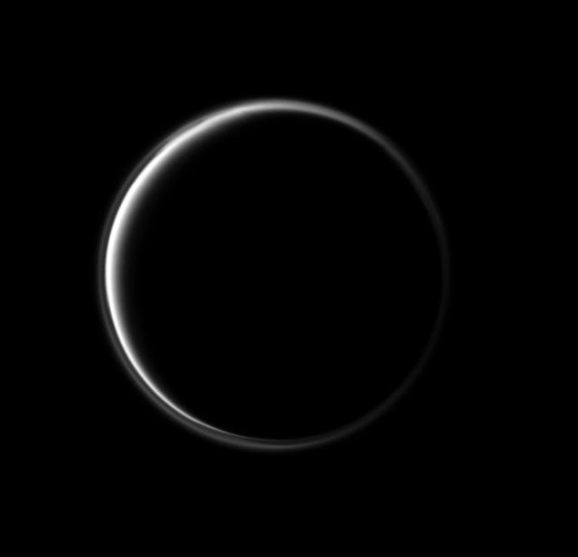 In this stunning image, NASA Cassini spacecraft looks at the dark side of Saturn largest moon. The narrowing circle of light surrounding Titan is produced by sunlight scattering through Titan atmosphere.