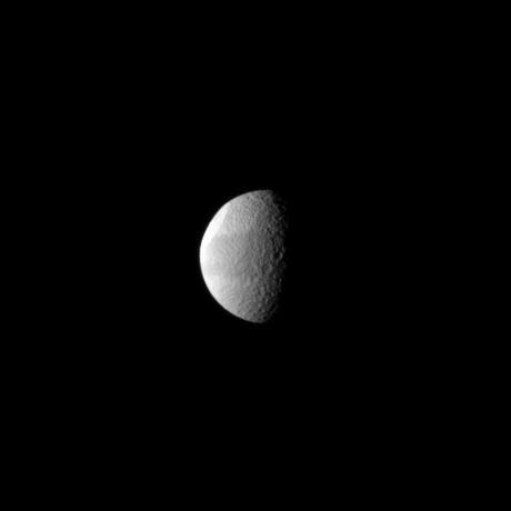 Tethys huge Odysseus Crater is brightly lit in the northern latitudes of this Saturnian moon in this NASA Cassini spacecraft view. The crater is seen almost edge-on in the upper left of the image.